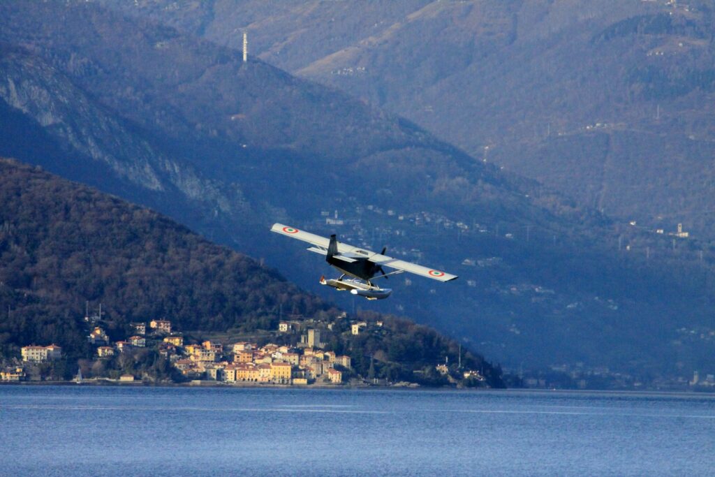 a small plane flying over a body of water.