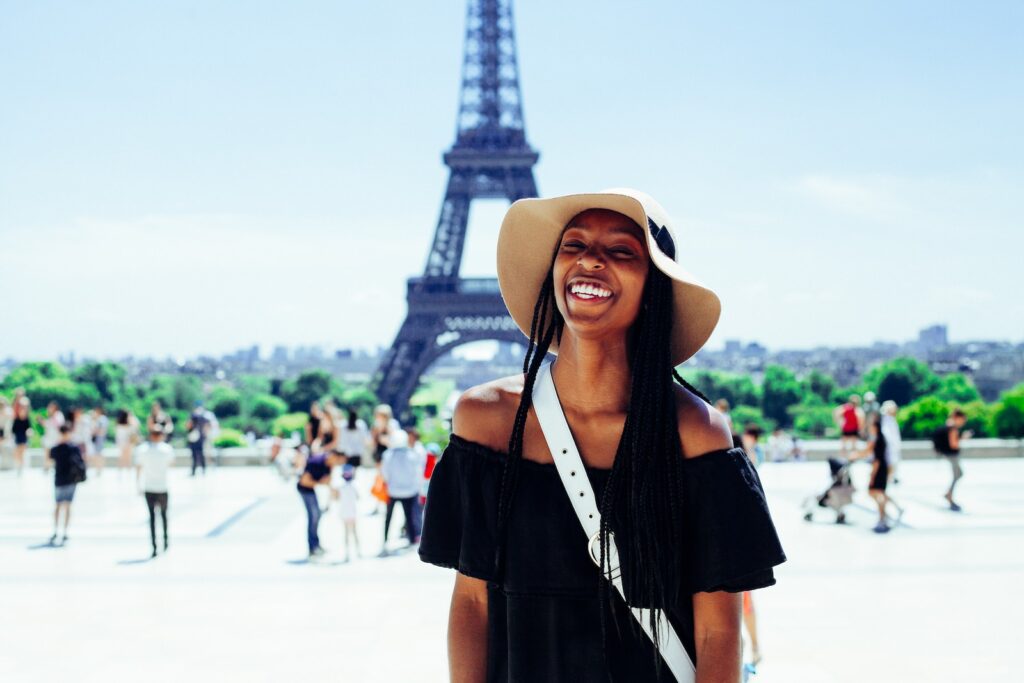 woman standing behind Eiffel Tower during daytime. Blacks Traveling to Europe